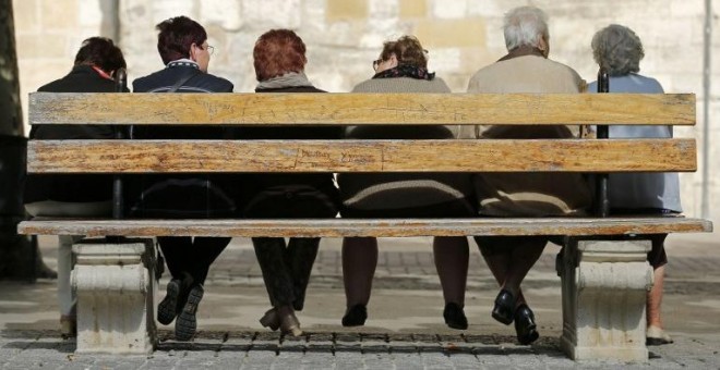 Varios pensionistas sentados en un banco en la localidad burgalesa de Briviesca. AFP