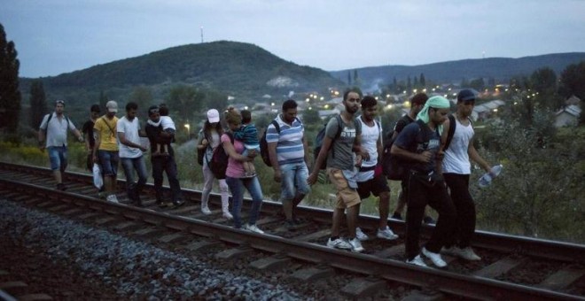 Inmigrantes caminan por las vías hacia la frontera de Austria. EFE/Balasz Mohai