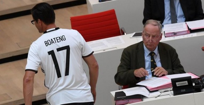 El un diputado regional de la CDU pasa junto a Alexander Gauland (Derecha), del partido anti-inmigración Alternativa para Alemania, con una camiseta del jugador del Bayer de Múnich Jerome Boateng. Gauland afirmó que Boateng, cuyo padre es ghanés, es un bu