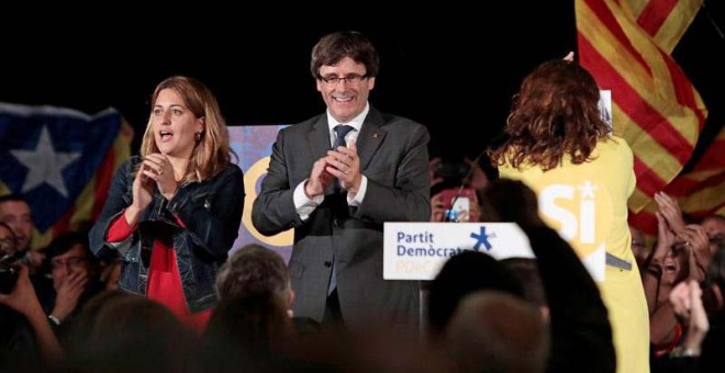 El presidente de la Generalitat, Carles Puigdemont y la coordinadora general del PDeCAT, Marta Pascal, durante el acto que el partido ha celebrado esta noche en Sant Cugat del Vallés. | SUSANNA SÁEZ (EFE)