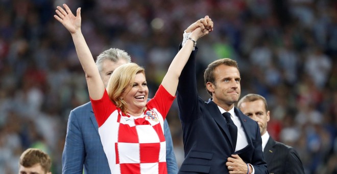 Emmanuel Macron levanta la mano de la presidenta de Croacia Kolinda Grabar-Kitarovic. REUTERS