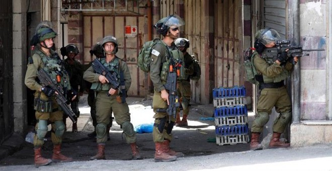 20/07/2018.- Varios soldados israelíes toman posiciones durante los enfrentamientos con palestinos registrados en la ciudad cisjordana de Hebrón, el 20 de julio del 2018. EFE/Abed Al Hashlamoun