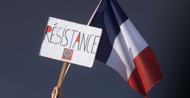 Un manifestante tiene una bandera francesa y un logo de la Francia Insumisa que dice: 'Resistencia'. REUTERS / Philippe Wojazer