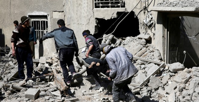 Varias personas trasladan uno de los heridos en los bombardeos de la ciudad rebelde de Hamouriyeh, en la región siria de Guta, cerca de Damasco. REUTERS/Bassam Khabieh