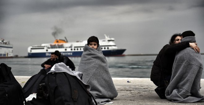 Un niño refugiado cubierto con mantas en el puerto de Mitilene, en Lesbos. ARIS MESSINIS / AFP