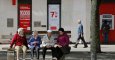 Varios pensionistas sentados en un banco cerca de una oficina bancaria en la localidad burgalesa de Briviesca. AFP / César Manso