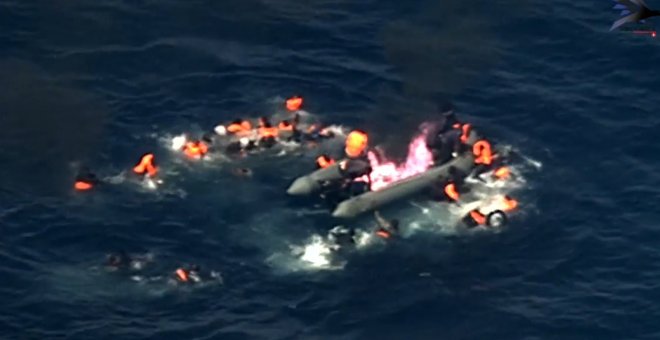 Imagen de la embarcación incendiada y de sus ocupantes en el agua.- FRONTEX
