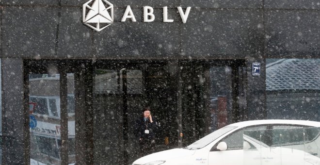 Un guardia de seguridad habla por su teléfono móvil en la entrada de la sede del banco ABLV, en Riga, la capital de Letonia. REUTERS/Ints Kalnins