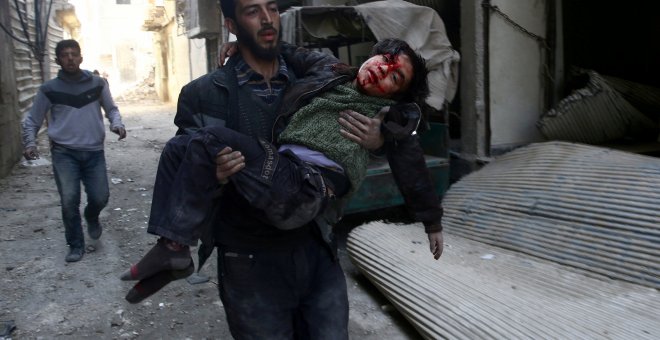 Un joven traslada a un niño herid por los bombardeos en la ciudad siria de Guta, cerca de Damasco. REUTERS/Bassam Khabieh
