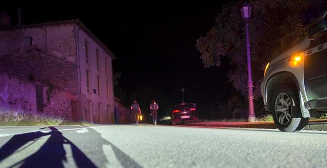 Dos agentes de la Guardia Civil cortan la carretera que da acceso a la casa del hombre atrincherado. (EFE)