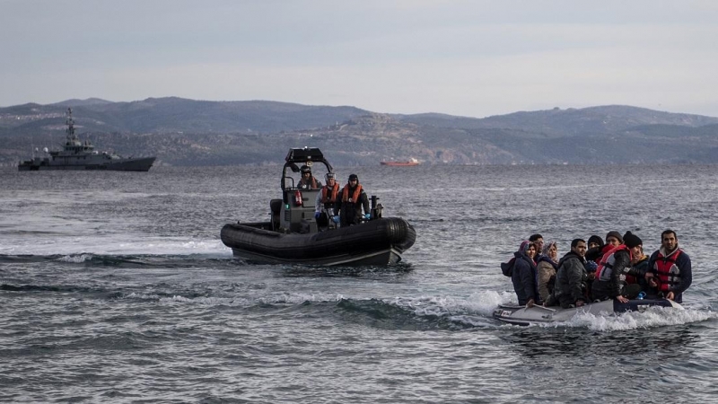 Un bote salvavidas con refugiados llega a la isla griega de Lesbos, junto al bote patrullero de las tropas fronterizas británicas HMC Valiant, que forma parte de la misión Frontex, a 28 de febrero de 2020.