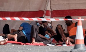 Un grupo de migrantes magrebíes, en el suelo del muelle del puerto de Arguineguín, en Gran Canaria, tras ser rescatados por Salvamento Marítimo.- EFE/ Ángel Medina G.